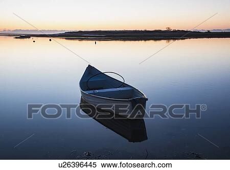 Stock Photography - USA, Massachusetts, Cape Cod, Chatham, Boat reflecting in water at dawn. Fotosearch