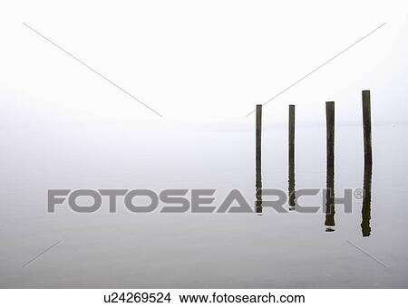 Picture - USA, Massachusetts, Cape Cod, Eastham, Wooden posts in fog. Fotosearch