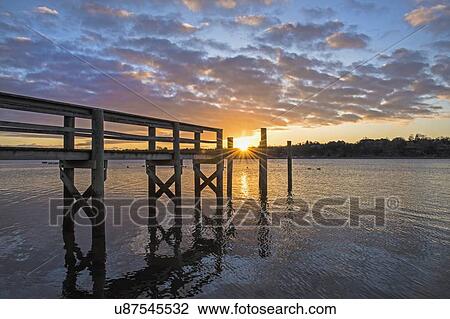 Stock Image - USA, Massachusetts, Cape Cod, Eastham, Jetty at sunrise. Fotosearch