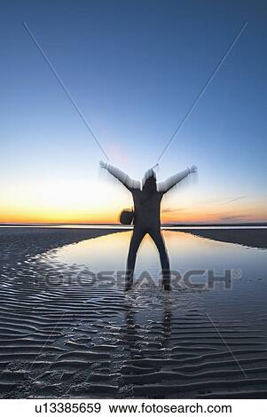 USA, Massachusetts, Cape Cod, Orleans, Man jumping on beach at sunset View Large Photo Image Stock Photo - USA, Massachusetts, Cape Cod, Orleans, Man jumping on beach at sunset. Fotosearch