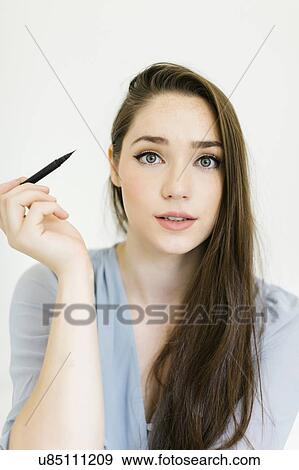 Stock Photo - Woman applying eyeliner. Fotosearch
