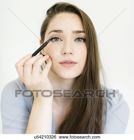 Stock Photograph - Woman applying eyeliner. Fotosearch