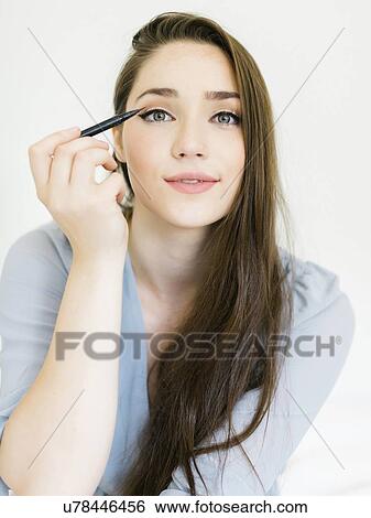 Stock Photograph - Woman applying eyeliner. Fotosearch