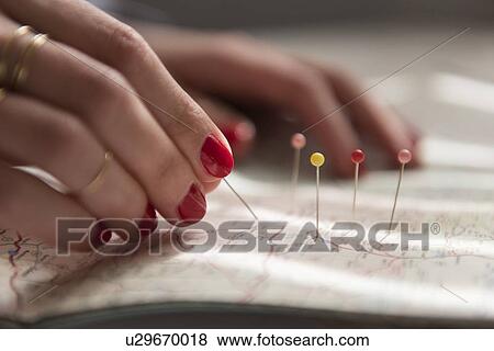 Stock Photo - Woman applying pins on map. Fotosearch