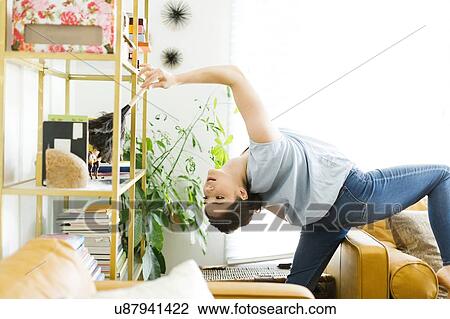 Woman bending over backwards while dusting View Large Photo Image Stock Image - Woman bending over backwards while dusting. Fotosearch