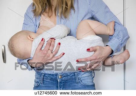 Woman breastfeeding baby girl (12-17 months) View Large Photo Image Stock Image - Woman breastfeeding baby girl (12-17 months). Fotosearch