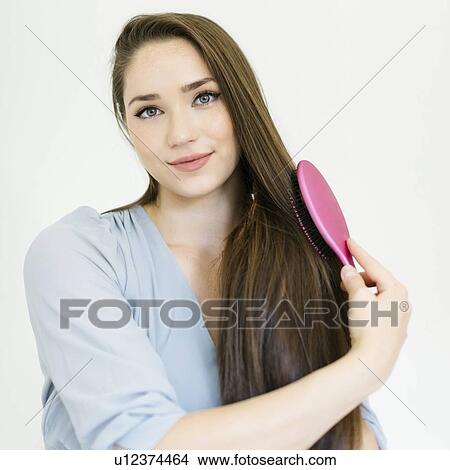 Woman brushing her hair View Large Photo Image Picture - Woman brushing her hair. Fotosearch