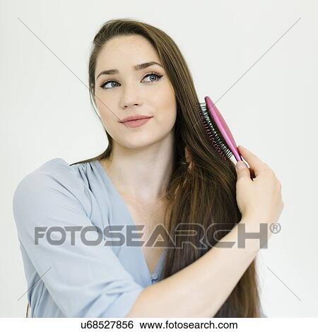 Woman brushing her hair View Large Photo Image Stock Photograph - Woman brushing her hair. Fotosearch