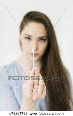 Stock Photograph - Woman holding cotton bud. Fotosearch