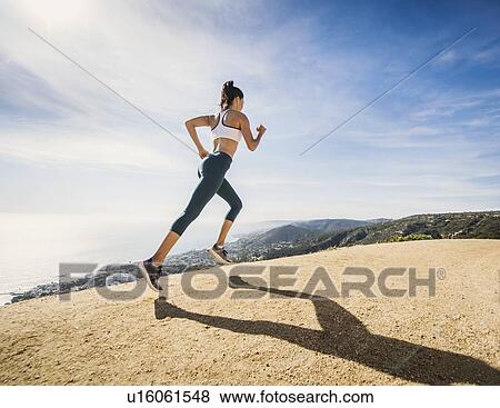 Stock Photo - Woman jogging on mountain. Fotosearch