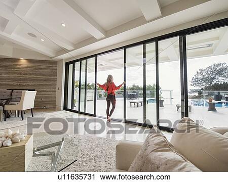 Woman looking out of house window View Large Photo Image Stock Image - Woman looking out of house window. Fotosearch