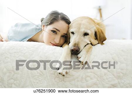 Woman lying on bed with dog View Large Photo Image Stock Image - Woman lying on bed with dog. Fotosearch