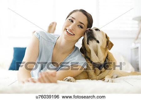 Woman lying on bed with dog View Large Photo Image Stock Photograph - Woman lying on bed with dog. Fotosearch