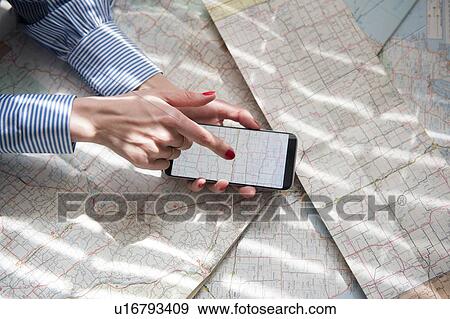 Stock Photo - Woman photographing map with smartphone. Fotosearch