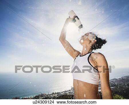 Woman pouring water on her head View Large Photo Image Picture - Woman pouring water on her head. Fotosearch