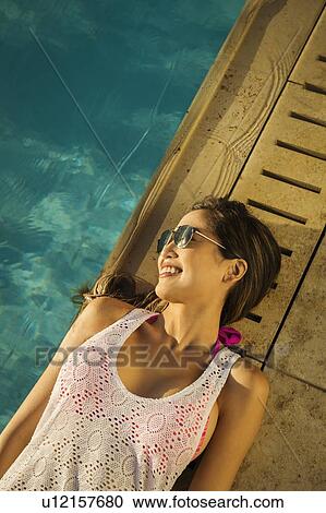 Woman relaxing by swimming pool View Large Photo Image Stock Image - Woman relaxing by swimming pool. Fotosearch