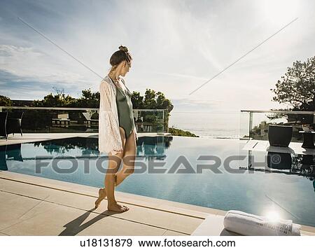 Woman relaxing by swimming pool View Large Photo Image Stock Photo - Woman relaxing by swimming pool. Fotosearch