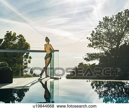 Stock Photo - Woman relaxing by swimming pool. Fotosearch