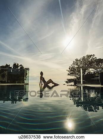 Woman relaxing by swimming pool View Large Photo Image Stock Photo - Woman relaxing by swimming pool. Fotosearch