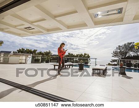 Stock Photo - Woman relaxing by swimming pool. Fotosearch