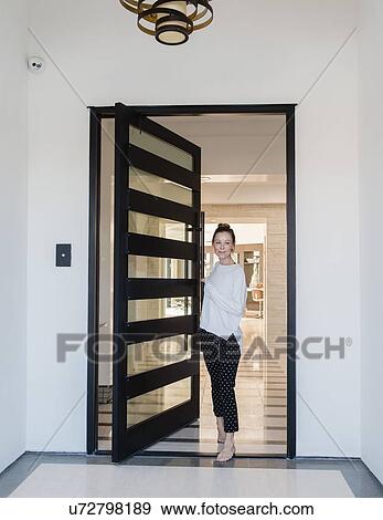 Woman standing in doorway of house View Large Photo Image Stock Photo - Woman standing in doorway of house. Fotosearch