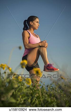Picture - Woman stretching against blue sky. Fotosearch