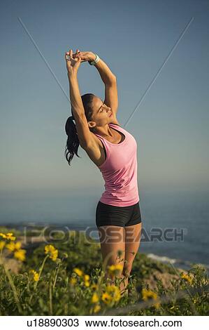 Woman stretching against blue sky View Large Photo Image Stock Image - Woman stretching against blue sky. Fotosearch