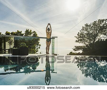 Woman stretching by swimming pool View Large Photo Image Stock Photography - Woman stretching by swimming pool. Fotosearch