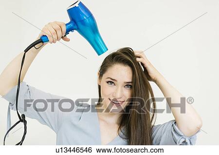Stock Photograph - Woman using hair dryer. Fotosearch