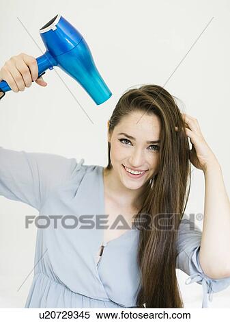Woman using hair dryer View Large Photo Image Stock Photography - Woman using hair dryer. Fotosearch