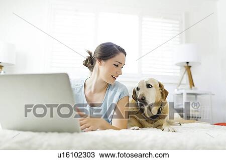 Woman using laptop with dog View Large Photo Image Stock Image - Woman using laptop with dog. Fotosearch