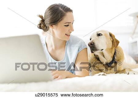 Woman using laptop with dog View Large Photo Image Stock Photography - Woman using laptop with dog. Fotosearch