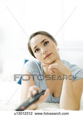 Woman using remote control on bed View Large Photo Image Stock Image - Woman using remote control on bed. Fotosearch