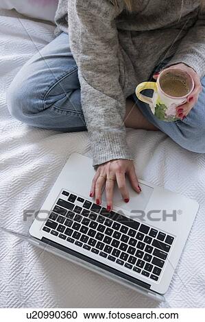 Woman with coffee and laptop in bed View Large Photo Image Stock Image - Woman with coffee and laptop in bed. Fotosearch