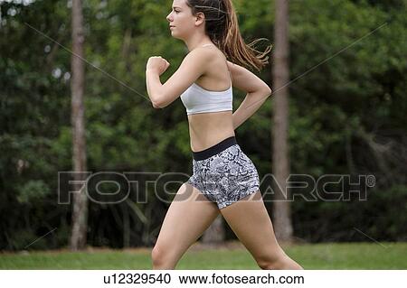 Young woman jogging in park View Large Photo Image Stock Image - Young woman jogging in park. Fotosearch