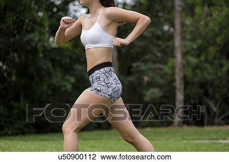 Young woman jogging in park View Large Photo Image Stock Image - Young woman jogging in park. Fotosearch