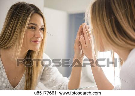 Young woman looking in mirror View Large Photo Image Stock Image - Young woman looking in mirror. Fotosearch
