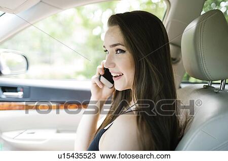 Young woman on phone in car View Large Photo Image Stock Image - Young woman on phone in car. Fotosearch
