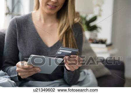 Stock Image - Young woman online shopping. Fotosearch