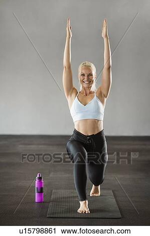 Stock Image - Young woman practicing yoga. Fotosearch