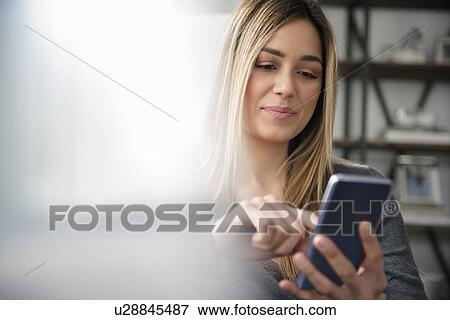 Stock Photo - Young woman text messaging. Fotosearch