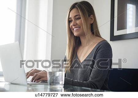 Young woman using laptop View Large Photo Image Stock Photo - Young woman using laptop. Fotosearch