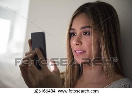 Young woman using smart phone View Large Photo Image Picture - Young woman using smart phone. Fotosearch