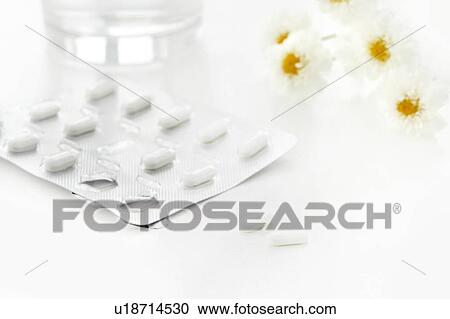 Stock Image - Antihistamine tablets and flowers, studio shot.. Fotosearch