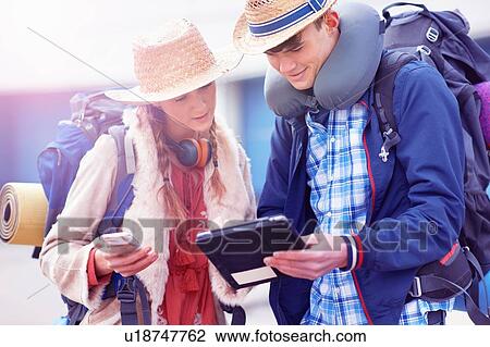 Stock Image - Backpacker couple using digital tablet. Fotosearch