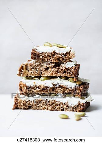 Stock Image - Banana bread slices with cream cheese frosting. Fotosearch