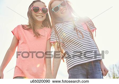 Stock Image - Best friends walking hand in hand. Fotosearch