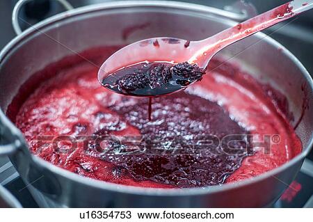 Stock Image - Blackberries simmering in large saucepan, close up. Fotosearch