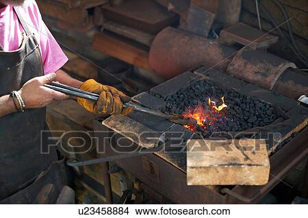 Picture - Blacksmith working in his forge. Fotosearch