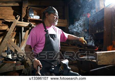 Blacksmith working in his forge View Large Photo Image Stock Photo - Blacksmith working in his forge. Fotosearch